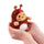 A small plush toy shaped like a reindeer character, with brown fur, a white belly patch, tan face and paws, brown antlers, and a red nose, photographed on a clean white background.